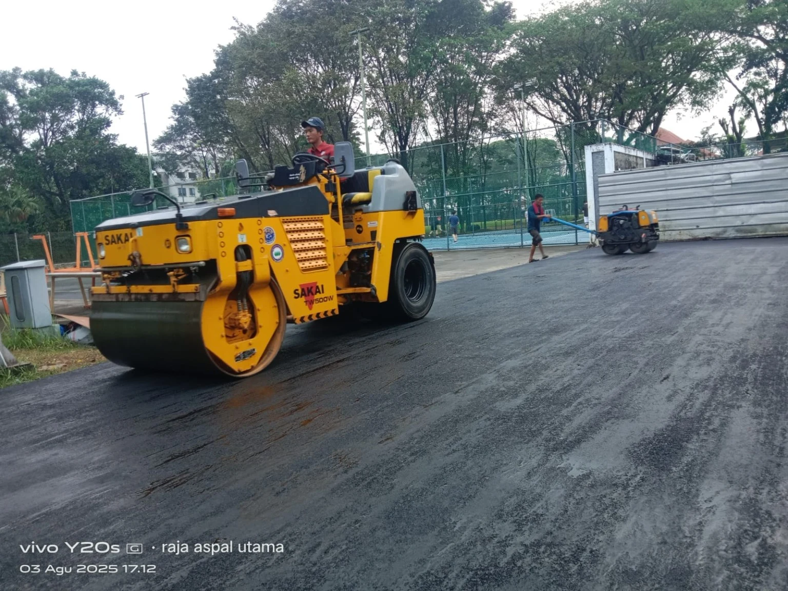 Pemadatan aspal menggunakan tandem roller Sakai