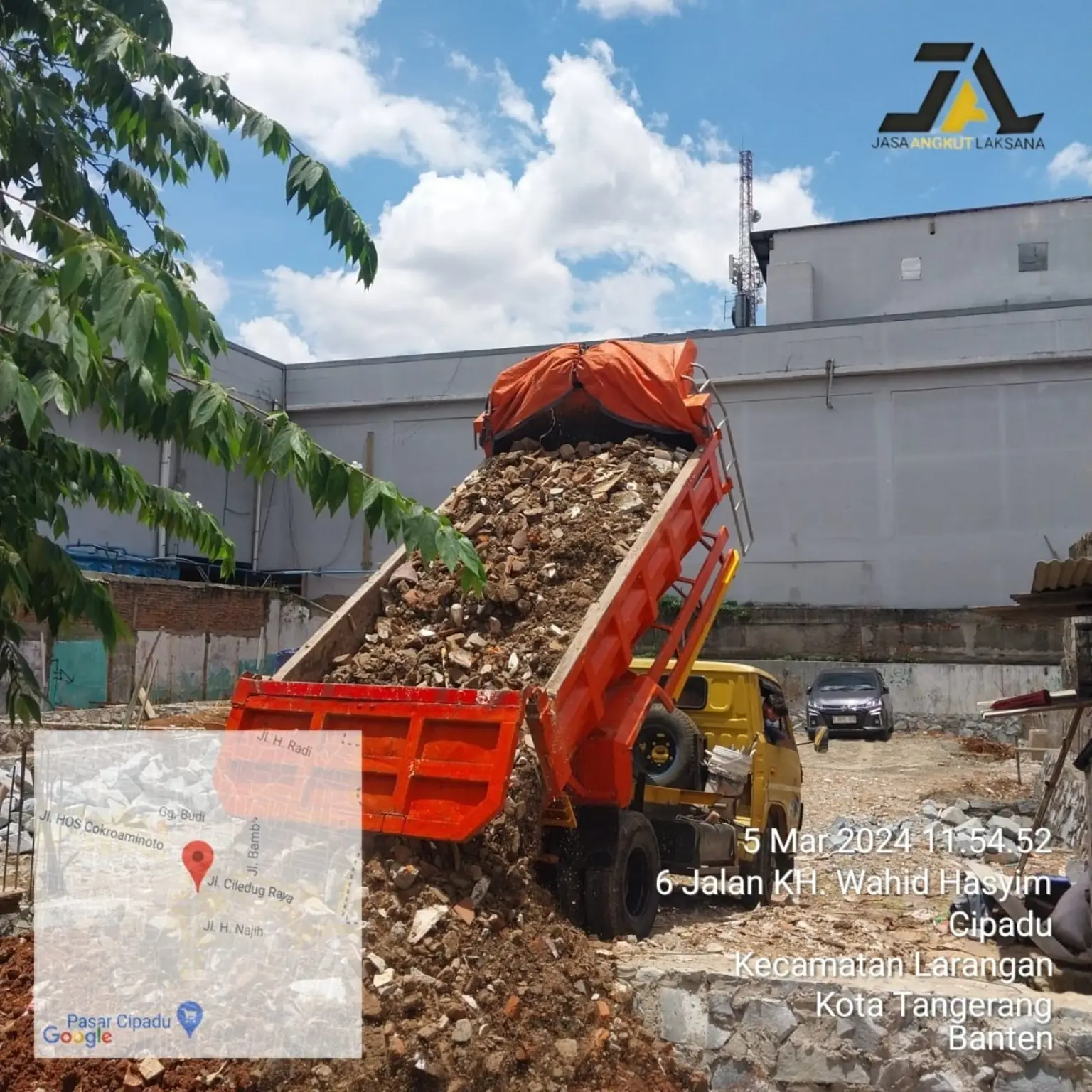 Dump truck menurunkan material untuk pengurugan lahan